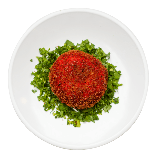Baked Mashed Potato surrounded in chopped parsley on a round white plate